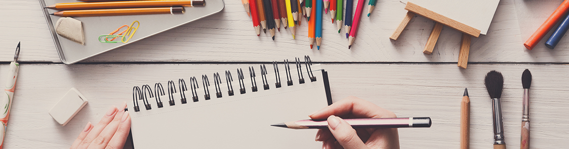 Pencils, crayons, paint brushes and a blank canvas